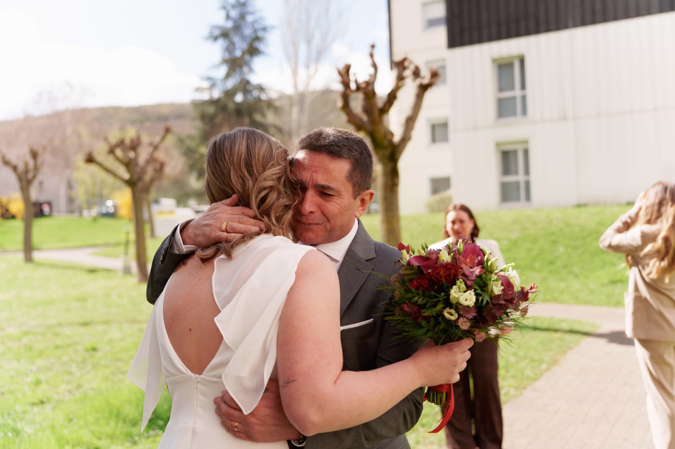 Père ému serrant la mariée dans ses bras