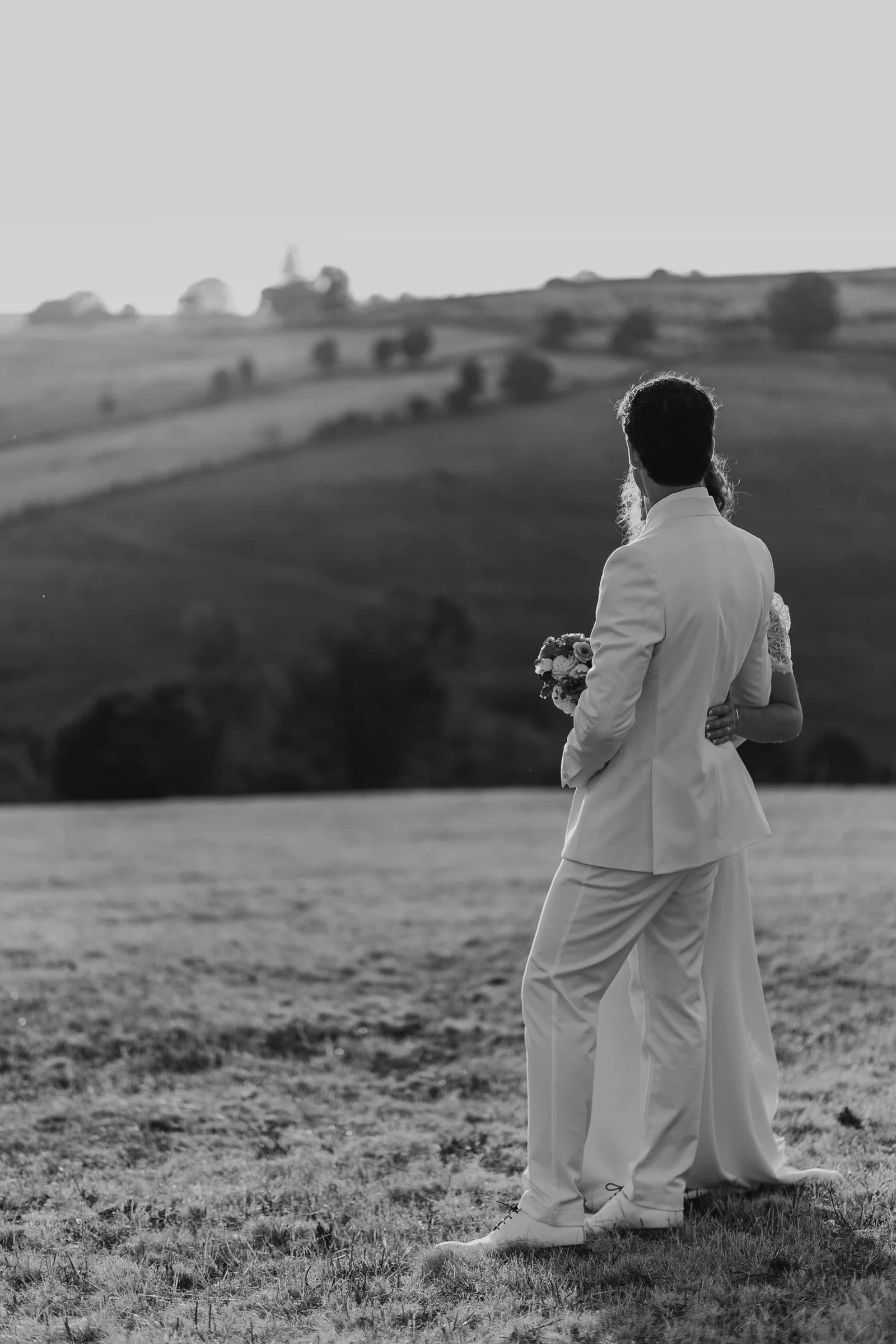 Portrait en noir et blanc des mariés face au paysage