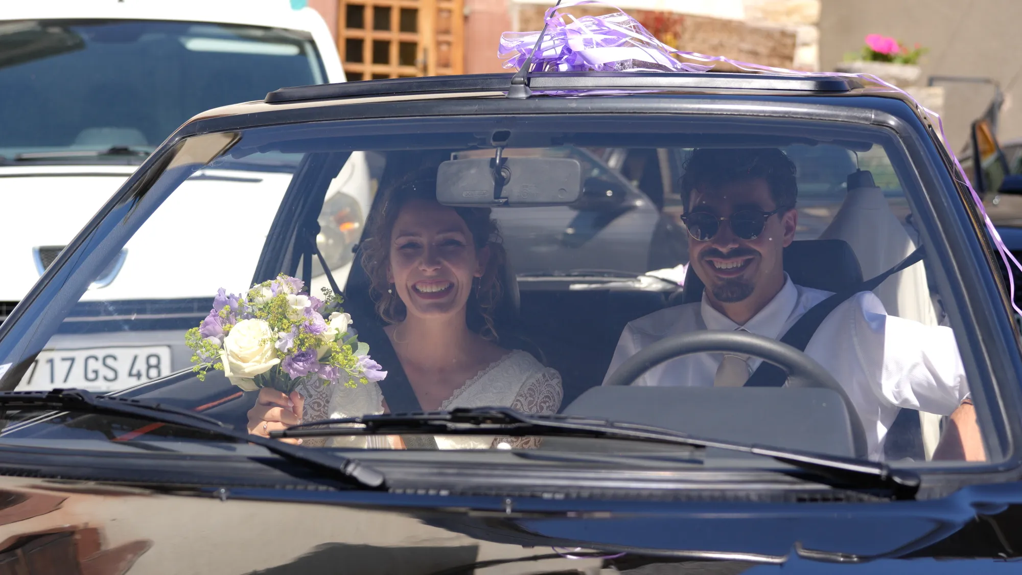 Les mariés sourient dans leur voiture décorée après la mairie de Banassac